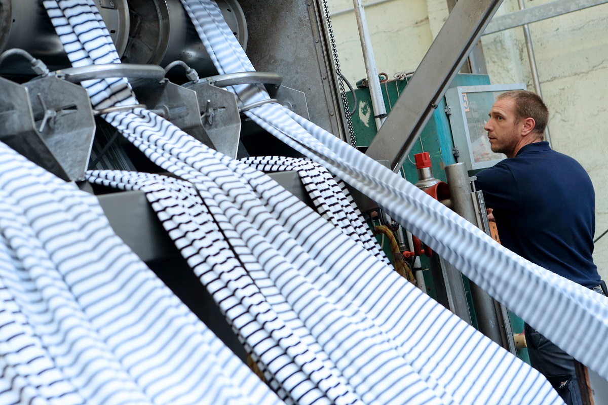 Quimper (29) : Usine de fabrication de vetements de la marque Armor-Lux, vetements marins dont les collections puisent leur inspiration dans les couleurs de la mer et les valeurs bretonnes. Employe au travail *** Local Caption *** -