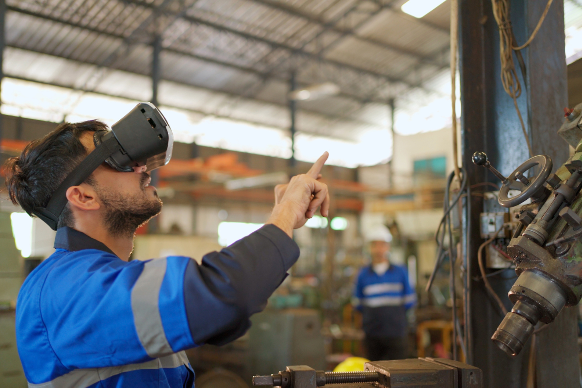 Ingénieur portant un casque de réalité virtuelle debout dans l’usine de fabrication.
